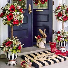 the front door is decorated with red flowers and bunnies for rabbits to sit on