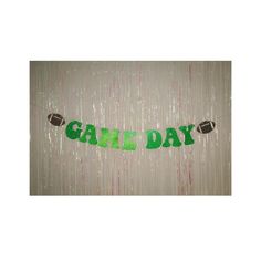 a banner that says gatl day hanging from the side of a wall with footballs on it