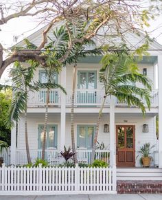 a white house with palm trees in front of it