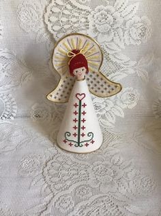 an angel figurine is sitting on a white lace tablecloth