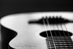 a black and white photo of an acoustic guitar