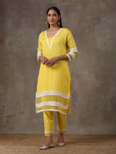 A two piece set comprising of a sunshine yellow kurta with pants. Curated in premium soft cotton, the kurta has lace detailing on the neck,hem and sleeves. Paired with straight cut soft cotton pants adding a slight organza touch to it ,it is finished with lace detailing. Color: Yellow Fabric Composition: Soft cotton Note: The product will be delivered within20-25 days of order placed Care Instruction: Dry Clean Only. Do not use heavy Iron Spring Straight Kurta Set With Gota Work, Spring Sets With Gota Work And Straight Kurta, Festive Straight Kurta With Lace Trim, Yellow Sets With Gota Work For Spring, Spring Yellow Sets With Gota Work, Traditional Lace Trim Set For Spring, Traditional Spring Sets With Lace Trim, Festive Cotton Sets With Lace Trim, Cotton Lace Work Sets With Long Sleeves