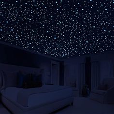 a bedroom with stars on the ceiling and bed in the foreground, blue lighting