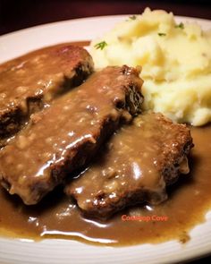 some meat and gravy on a plate with mashed potatoes