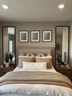 a large bed sitting under three mirrors in a bedroom