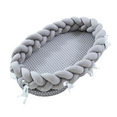 a gray and white beaded tray with tassels on the sides, sitting in front of a white background