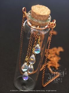 a bottle filled with lots of different items on top of a black table next to a gold chain