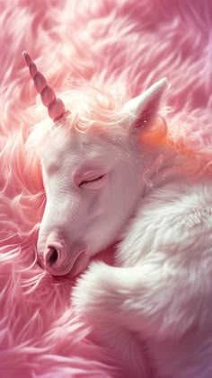 a white unicorn sleeping on top of a pink fluffy blanket with its eyes closed and it's head turned to the side