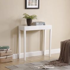 a white table with magazines and a potted plant sitting on it's side