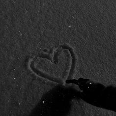 someone is drawing a heart in the snow