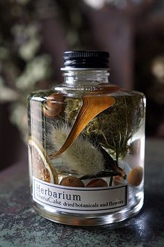 a bottle filled with plants and nuts on top of a table