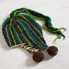 a crocheted hat with two pompons on it