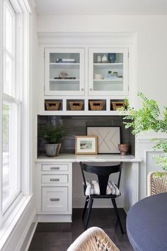 a home office with white cabinets and wicker chairs in front of the desk area