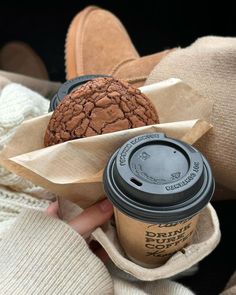 a person holding a cup of coffee and a cookie