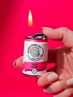 a person holding a can with a lighter in it