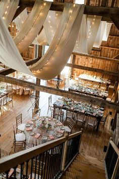 the inside of a large building with tables and chairs set up for a wedding reception