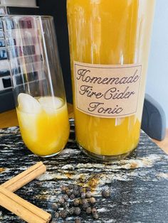 a bottle of homemade fire cider tonic next to cinnamon sticks