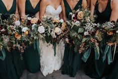 a group of bridesmaids in green dresses holding bouquets with greenery and flowers