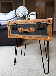 an old suitcase with hairpin legs is sitting on the floor next to a coffee table