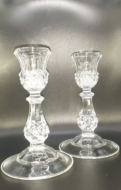 two clear glass candlesticks sitting side by side