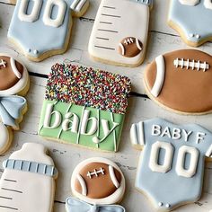 baby shower cookies decorated like sports equipment and footballs are arranged on a white table