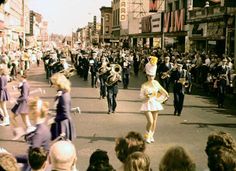 people are walking down the street with parade goers in the backgrouns