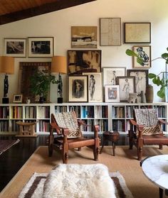 a living room filled with lots of furniture and pictures on the wall above it's bookshelf