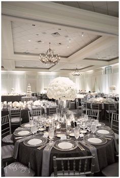 an elegant table setting with black and white linens, centerpieces and flowers