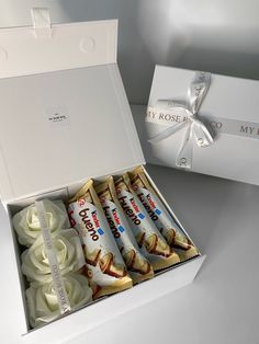 an open box with white chocolates in it and a bow on the top one