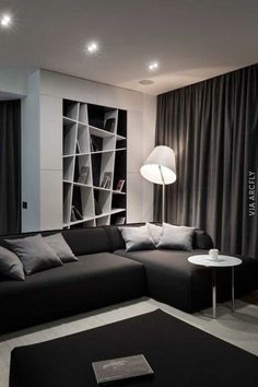 a black and white living room with modern furniture in the corner, large bookshelf on the wall