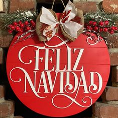 a red sign that says feliz navidad hanging on a brick wall