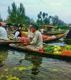 several people in boats filled with vegetables on the water