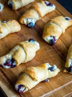 croissants with blueberries are on a cutting board and ready to be eaten