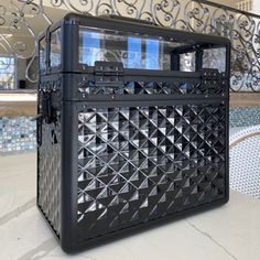 a large black box sitting on top of a table next to a bannister