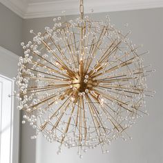 a chandelier hanging from the ceiling in a room with white walls and windows