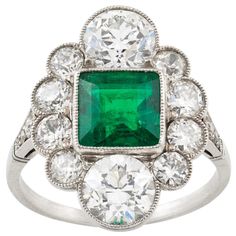 An Art Deco emerald and diamond ring, the square-cut emerald estimated to weigh 1.7 carats, accompanied by GCS Report stating to be of Colombian origin, vertically-set between two old European-cut diamonds each estimated to weigh approximately 1 carat and four smaller old-cut diamonds set on each side weighing approximately a further 1.2 carats, all mounted in platinum to D-section shank with diamond encrusted shoulders, head measuring 2x1.5cm, gross weight 5 grams, circa 1920. Finger size L Thi Art Deco Emerald, Art Deco Emerald Ring, Emerald And Diamond Ring, Antique Diamond Rings, Emerald Diamond Ring, Ring Art Deco, European Cut Diamonds, Emerald Engagement Ring, Art Deco Ring