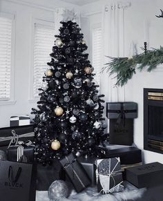 a black and gold christmas tree in a living room with presents on the floor next to it