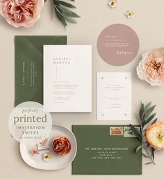 the wedding stationery is laid out with flowers and greenery