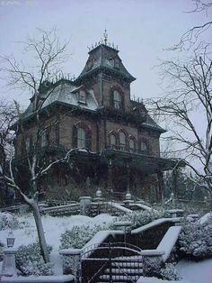 an old victorian house is covered in snow