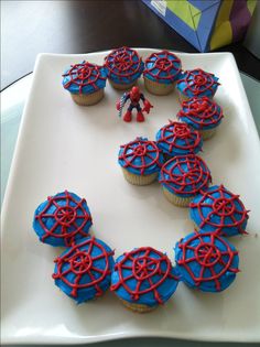 cupcakes with spiderman decorations are arranged in the shape of a circle on a plate