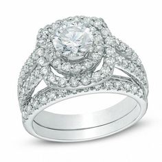 a white gold ring set with diamonds on the band and an oval shaped center stone