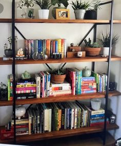 a bookshelf filled with lots of books and plants