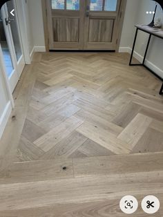 an image of a wooden floor in the middle of a room with doors and windows