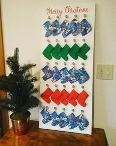 a christmas card with bows hanging on the wall next to a small potted tree