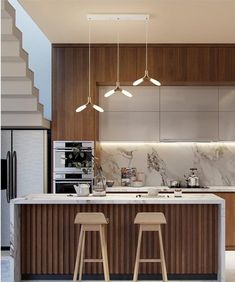 two stools sit in front of an island with marble countertops and wooden cabinets