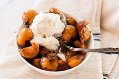 a bowl filled with potatoes and ice cream on top of a white towel next to a spoon