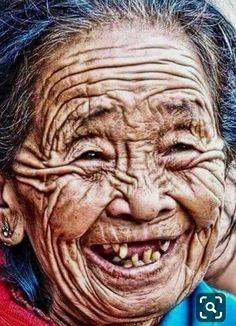 an old woman with wrinkles on her face and blue hair is smiling at the camera