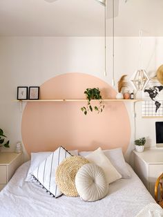 a bedroom with a bed, desk and shelves on the wall in front of it