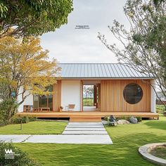 a small white house sitting on top of a lush green field