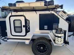 an off - road camper is parked on the sidewalk